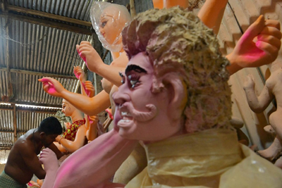 An idol maker gives the finishing touches to an idol of Goddess Durga at his studio in the Bypass area on the outskirts of Agartala ahead of the Durga Puja festival on October 3. 