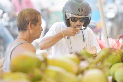 People are eating coconut water and soft coconut from a fruit vendor to beat the scorching heat in Agartala on July 4.