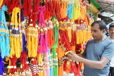 A shopkeeper arranges Rakhi items at a stall ahead of the festival at MG Bazar in Agartala on August 18.