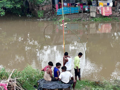 Youngsters catching fish as heavy rain triggers waterlogging in low lying areas of Agartala on July 13.