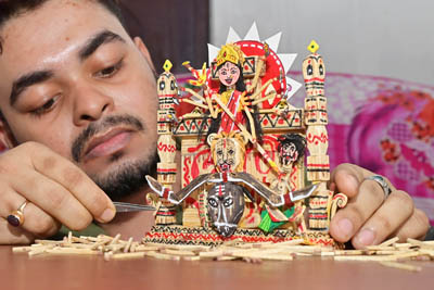Bijoy Debnath, a 26-year-old artist, gives the finishing touches to a Durga idol made entirely of 700 matchsticks ahead of Durga Puja, the biggest festival of Bengalis.