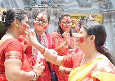 Women smear vermilion on each other face to celebrate the Ambabuchi festival in front Laxmi Narayan temple at Agartala on June 23, 2026.