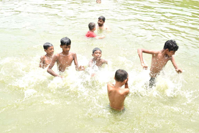 Children and youngsters enjoy a refreshing bath in College Tilla Lake amid the scorching heat in Agartala on June 2. 