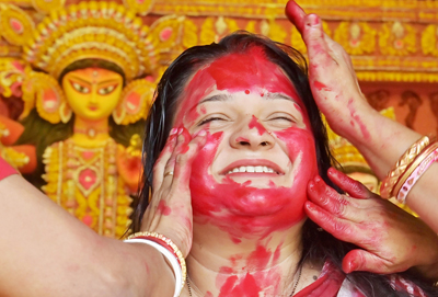 Women smear vermilion on each other's face to celebrate the Vijaya Dashimi festival in front of a Durga Puja pandal at Agartala on October 21.