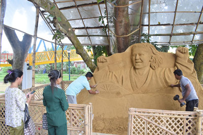 Sand artist Krishna Debnath creates a sand portrait of Commonwealth gold medallist Asmita Dey near Howra river in Agartala on August 4.