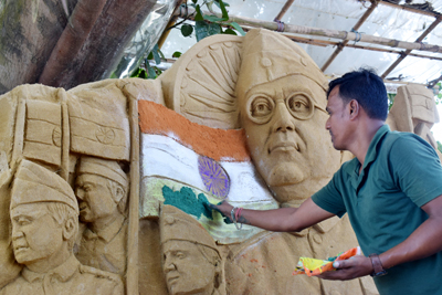 Sand artist Krishna Debnath creates special art on the occasion of Independence Day in the Howrah River basin in Agartala on August 13.
