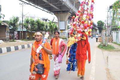 Devotees participate in a religious procession on their way to a Lord Shiva temple to offer prayers during the auspicious Bengali month of Shravan in Agartala on August 3 morning.